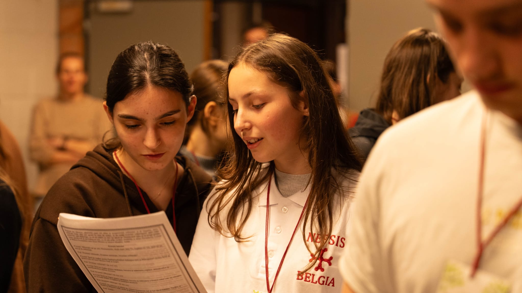 Două fete citind împreună dintr-o foaie în timpul unei activități de grup